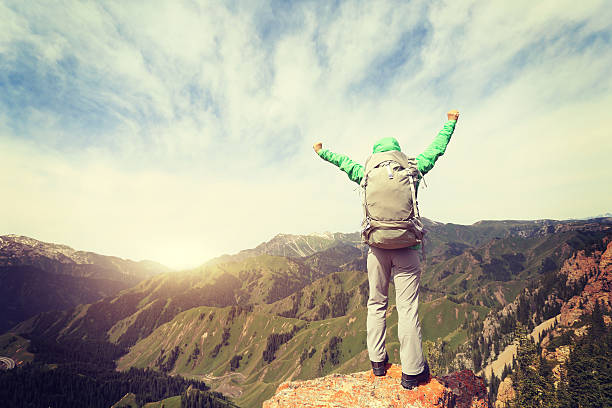 istock cheering successful woman backpacker open arms on mountain peak 586058598