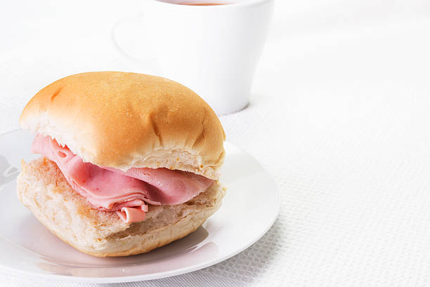 Ham bread roll or bap and a hot drink