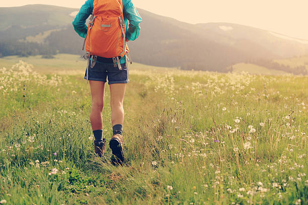 istock young woman hiker walking on trail in grassland 586060168
