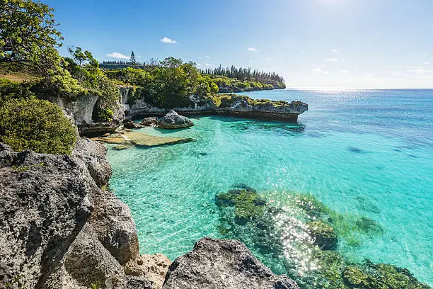 Maré Island, view over turquoise water at Tadine Bay, south-west coast of Maré Island with beautiful natural rocky lagoon and coral reef to the horizon under sunny blue summer sky Tadine Bay, Mare Island, Loyalty Islands, New Caledonia, Pacific Ocean Islands.