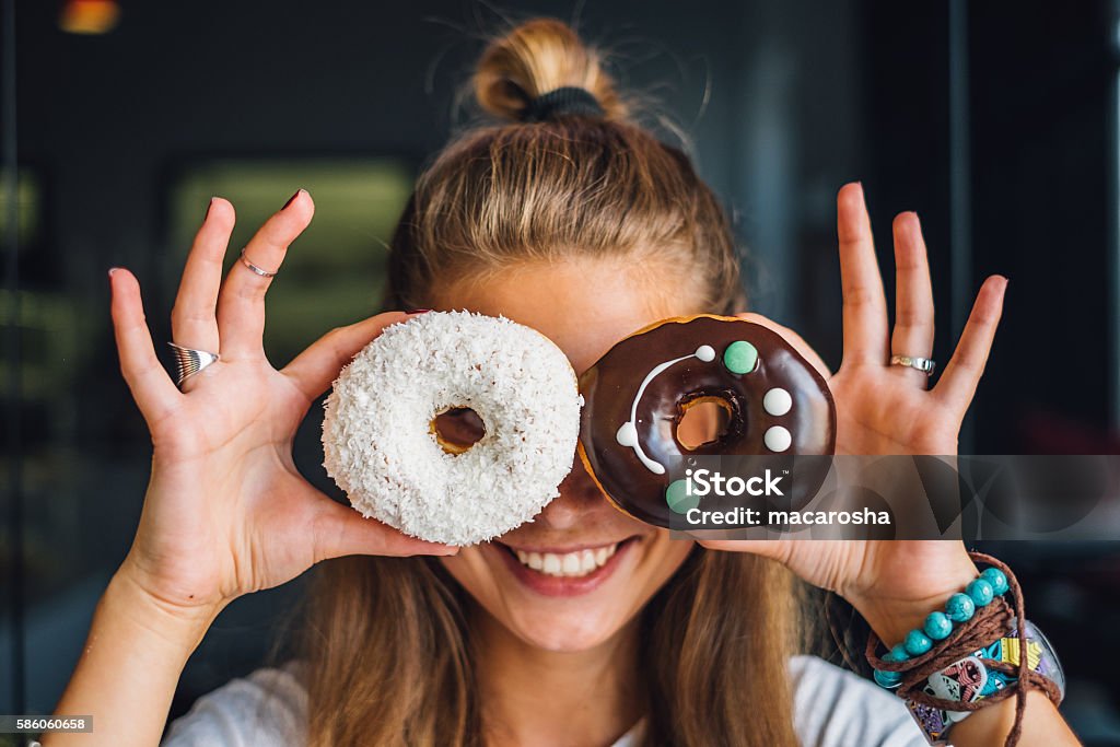 Femme heureuse tenant des beignets - Photo de Beignet libre de droits