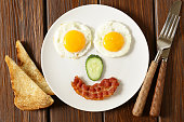 istock funny face serving breakfast, fried egg and toast 586060824