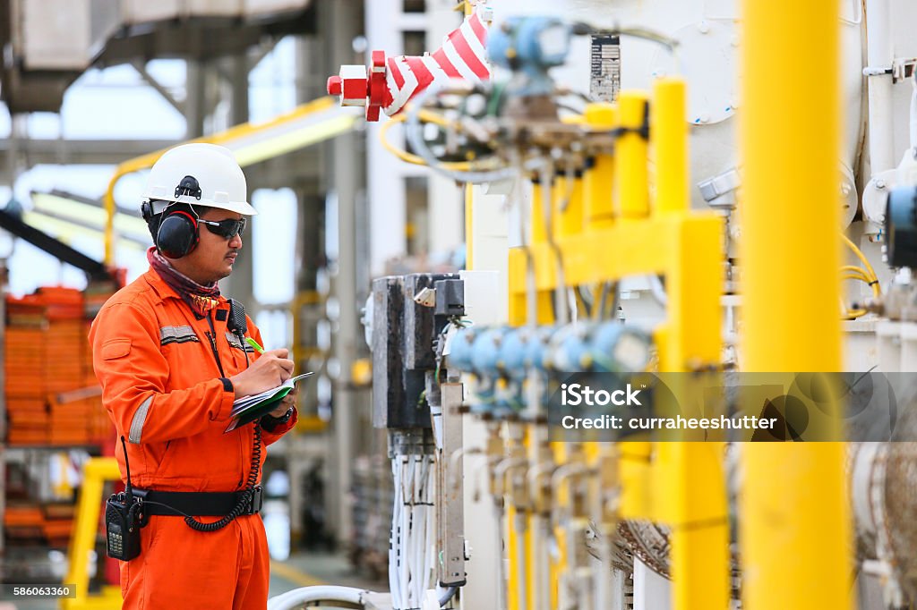 operator recording operation of oil and gas process operator recording operation of oil and gas process at oil and rig plant, offshore oil and gas industry, offshore oil and rig in the sea, operator monitor production process, routine daily record. Natural Gas Stock Photo