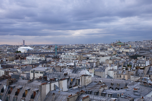 View over the zinc roofs of Paris right bank at sunset in summer. Column of Place Vendôme in the center, and the Opera on the right.  France.