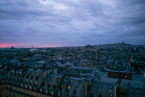 View over the zinc roofs of Paris right bank at sunset in summer. The Opera Garner, Montmartre and the Sacré Coeur in the background.  France.