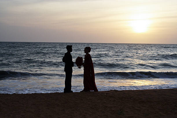 Colombo, Sri Lanka - August 18, 2005: married couple stands happy and romanticly at the beach on their wedding day in sunset