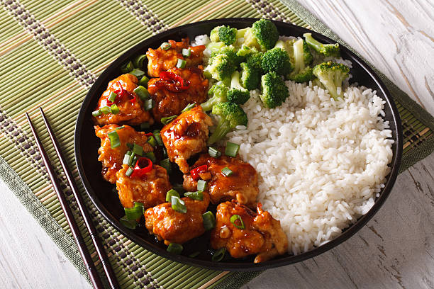 general tso's chicken with rice, onions and broccoli.  horizontal - chicken general tso food imagens e fotografias de stock