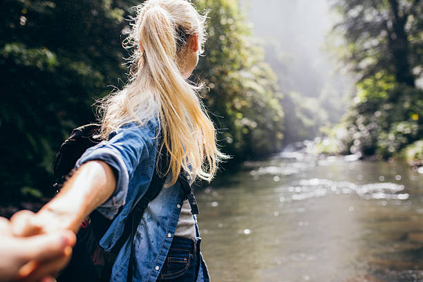 istock Couple crossing the creek holding hands 586072640