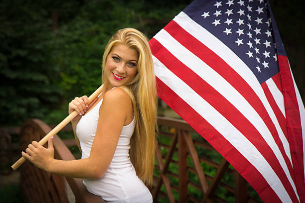 istock Blonde Girl Smiling While Holding American Flag 586074068