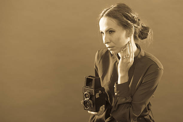 istock Woman taking picture with old camera 586074900