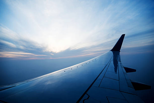 ala de avión en vuelo en la puesta de sol - wing airplane sky jet fotografías e imágenes de stock