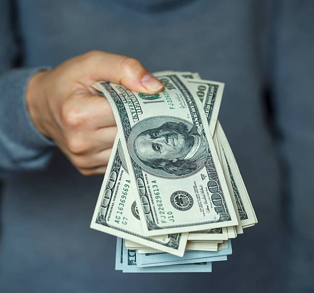 istock Woman hand with dollar bills 586075942