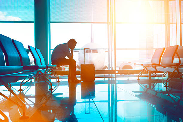 Tired airplane passenger wait for plane and covers his eyes
