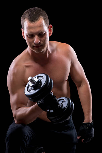 istock bodybuilder with dumbbell shot in the dark 586083418