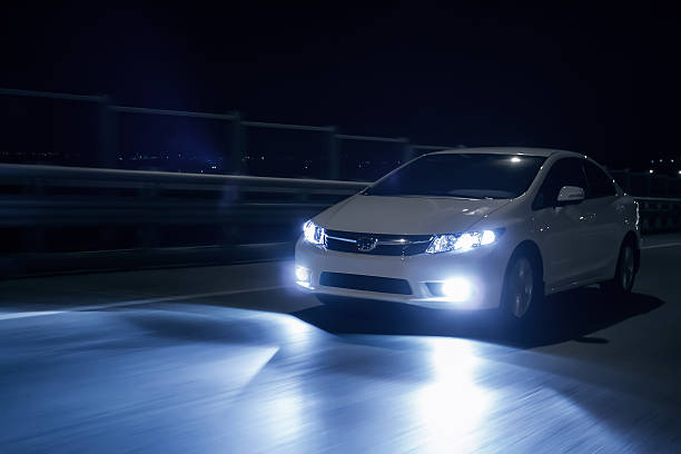 coche con faros de xenón conducción rápida en carretera a casi - faro luz de vehículo fotografías e imágenes de stock