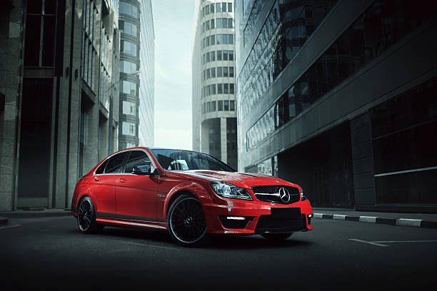 Red car Mercedes-Benz C63 stay on asphalt road in city stock photo