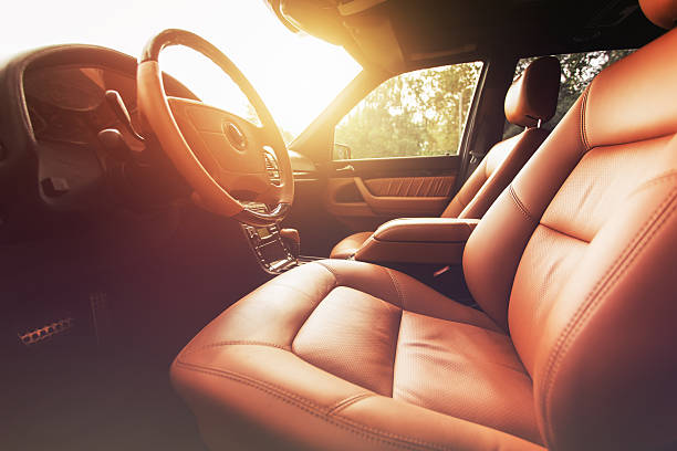 interior de coche premium, cuero marrón al atardecer - asiento fotografías e imágenes de stock