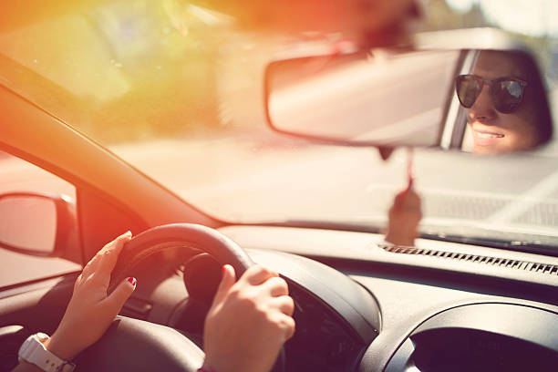 Smiling young woman driving a car.