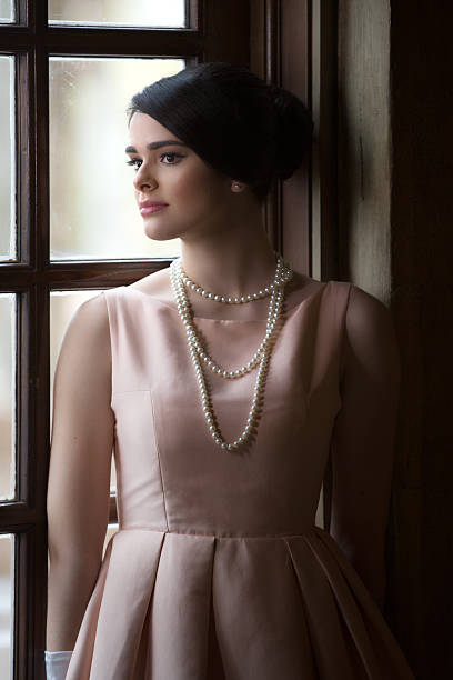 Designer is sewing pearls onto wedding dress (stock photo)