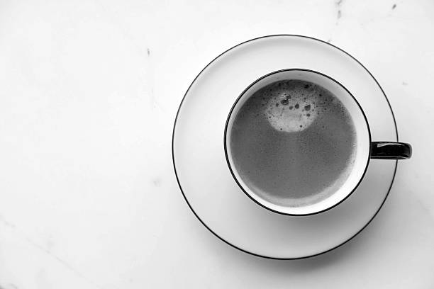 Cup of coffee on  marble desk, top viev  copy space