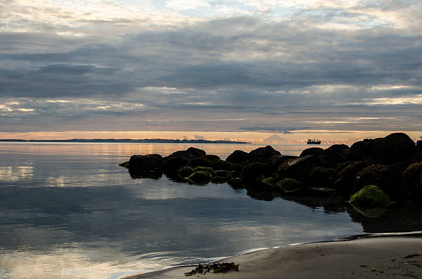 istock Beautiful sun rise with clouds reflected in the water 586161708