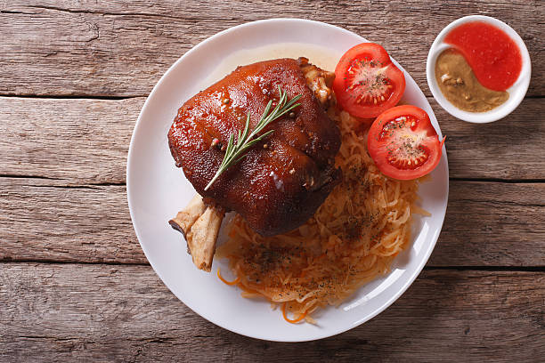 pork shank, sauerkraut and sauce. horizontal top view pork shank, sauerkraut and sauce on a plate on the table. horizontal top view pork hock stock pictures, royalty-free photos & images