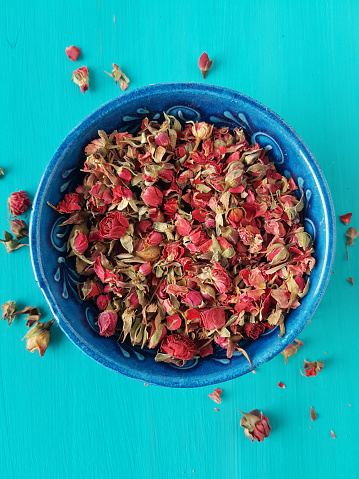 dried rose buds on a turquoise background