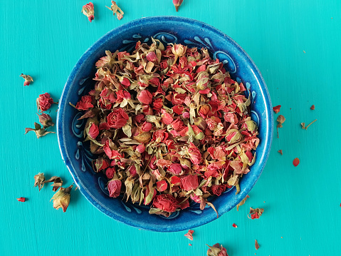 dried rose buds on a turquoise background