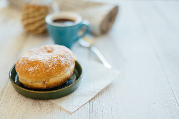 bismarck donut with coffee on wooden table for breakfast - bismarck donuts imagens e fotografias de stock