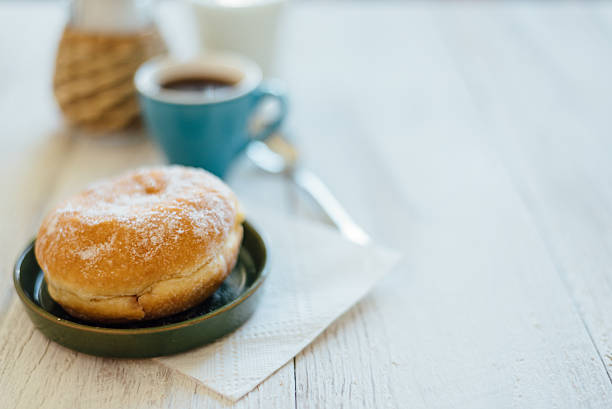 bismarck donut with coffee on wooden table for breakfast - bismarck donuts imagens e fotografias de stock