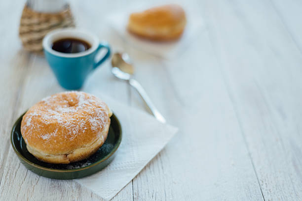 istock Bismarck donut with coffee on wooden table for breakfast 586163732