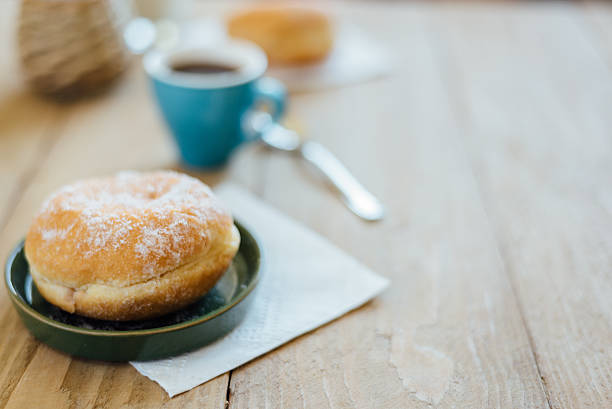 istock Bismarck donut with coffee on wooden table for breakfast 586163798