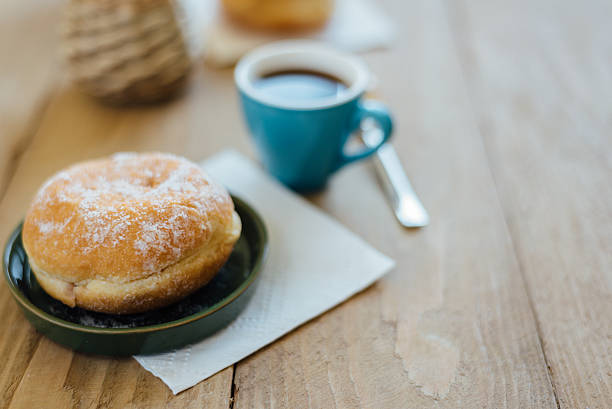 istock Bismarck donut with coffee on wooden table for breakfast 586163844