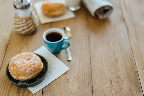 istock Bismarck donut with coffee on wooden table for breakfast 586163968
