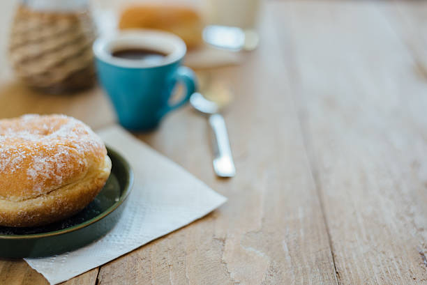 istock Bismarck donut with coffee on wooden table for breakfast 586164090