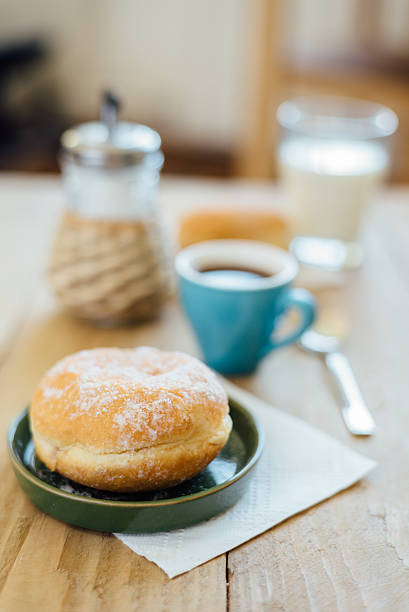 bismarck donut with coffee on wooden table for breakfast - bismarck donuts imagens e fotografias de stock