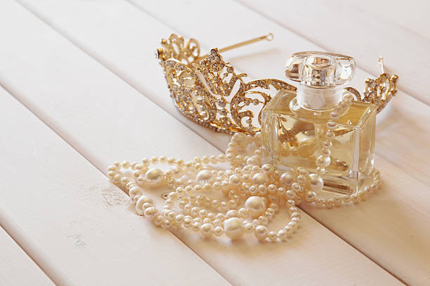 istock White pearls necklace, diamond tiara and perfume bottle 586165126