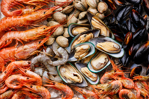 Close image of jumbo shrimp being sauteed in a pan with oregano, chive, rosemary, garlic and paprica creating Shrimp Scampi