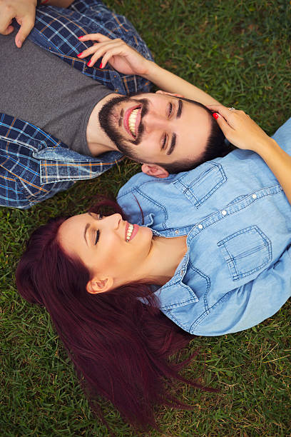 istock Top view of a young couple  lying together on grass 586167314