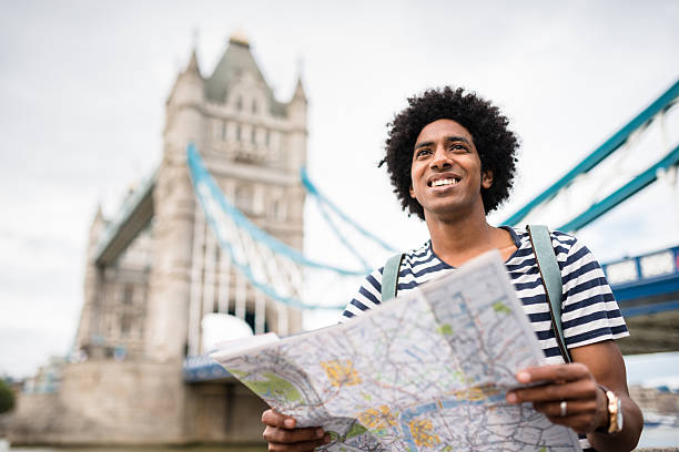 viaggiatore solitario nell'area del ponte della torre leggendo una mappa - tower bridge immagine foto e immagini stock