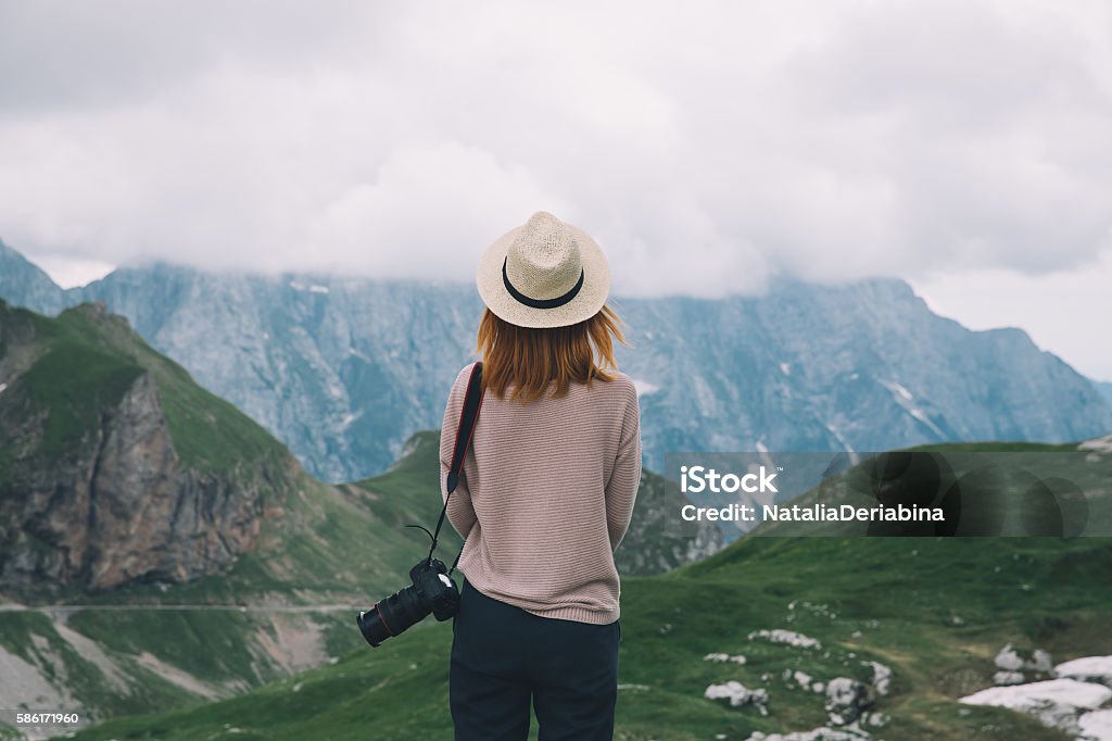 Young woman relaxing outdoor. Travel lifestyle Young woman relaxing outdoor travel freedom lifestyle with mountains on background. Fashionable girl in the Mangart is a mountain in the Julian Alps, located between Italy and Slovenia. Girls Stock Photo