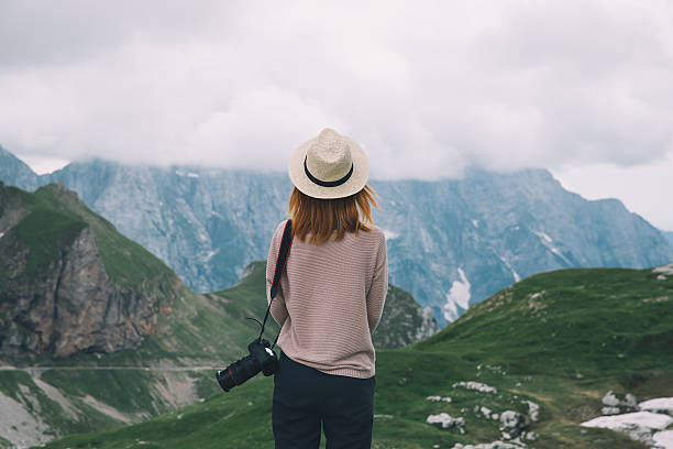 Young woman relaxing outdoor. Travel lifestyle Young woman relaxing outdoor travel freedom lifestyle with mountains on background. Fashionable girl in the Mangart is a mountain in the Julian Alps, located between Italy and Slovenia. dolomite photos stock pictures, royalty-free photos & images