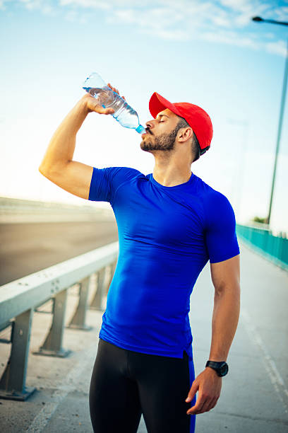 istock Athlete with strong abs drinking water 586173212