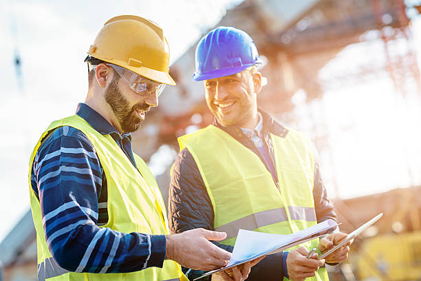 istock Main engineer showing report to contractor at construction site 586173368