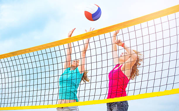 istock Two female friends playing beach volleyball 586174482