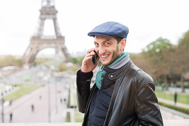 istock Young man using a smart phone near the eiffel tower 586176286