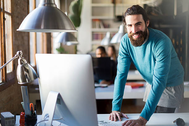 istock Young man working in a start up office smiling portrait 586176456