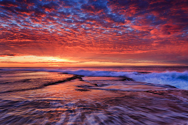 istock Sea mona vale pink sun over rockbed 586178496
