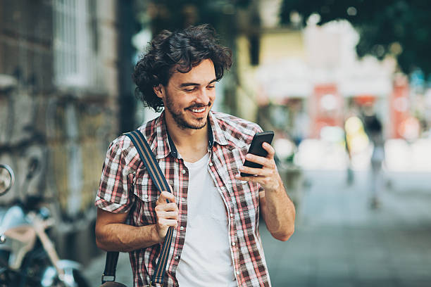 istock Man with smart phone walking on the street 586178706