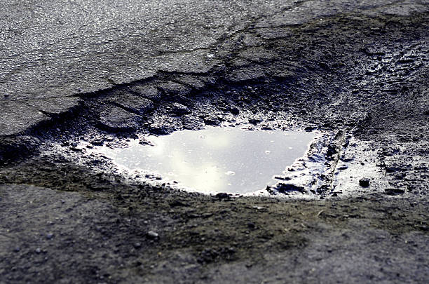 istock Hole in the road filled with water 586178792